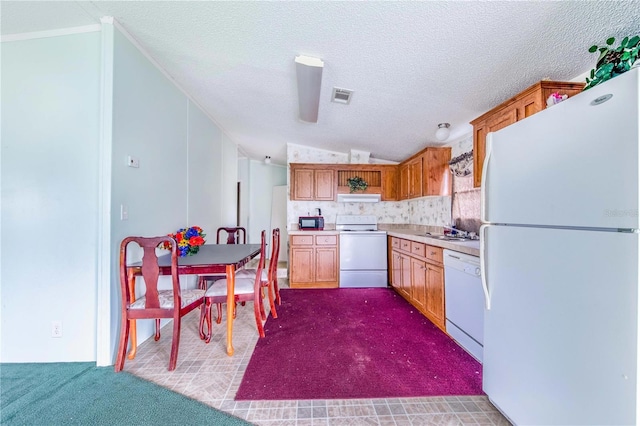 kitchen with white appliances, a textured ceiling, vaulted ceiling, sink, and carpet flooring