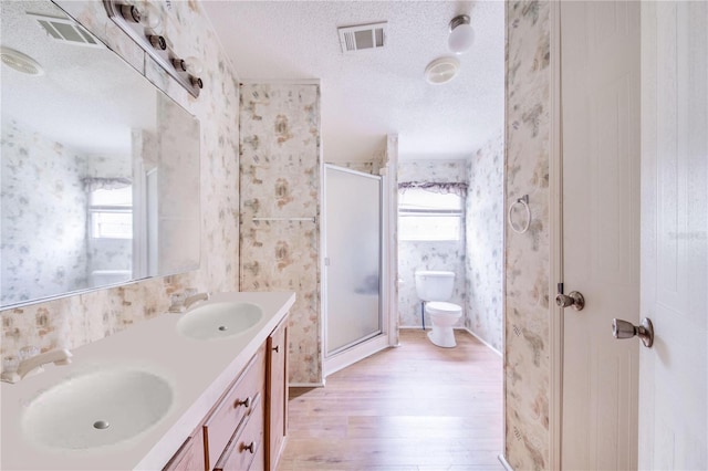 bathroom featuring toilet, plenty of natural light, hardwood / wood-style floors, and walk in shower