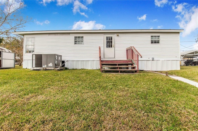 back of house with a lawn and central AC