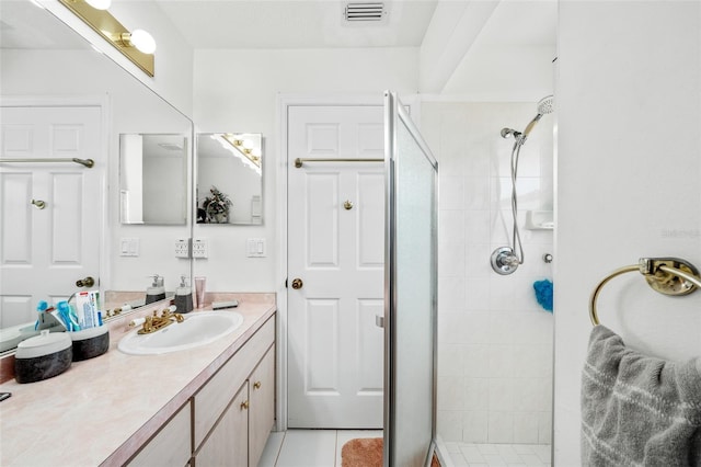 bathroom featuring tile patterned floors, vanity, and tiled shower