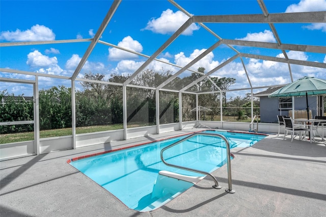 view of swimming pool featuring glass enclosure and a patio area