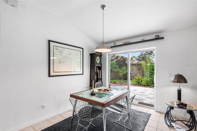 tiled dining space featuring lofted ceiling