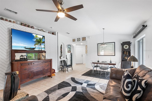 living room featuring ceiling fan, light tile patterned floors, and lofted ceiling