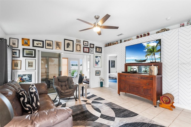 living room featuring ceiling fan, light tile patterned floors, and lofted ceiling