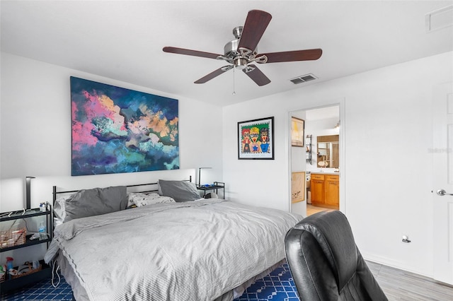 bedroom featuring ceiling fan, hardwood / wood-style floors, and ensuite bath