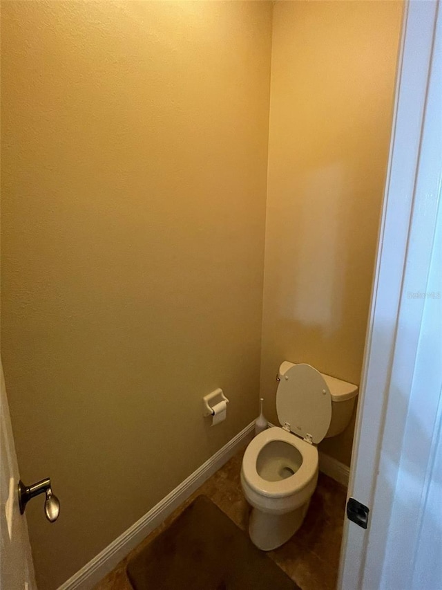 bathroom with toilet and tile patterned floors