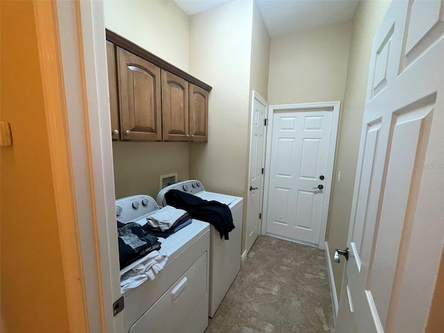 washroom with washer and clothes dryer and cabinets