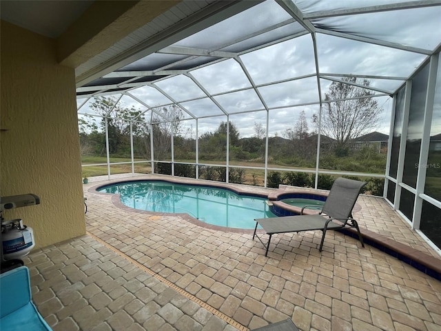 view of swimming pool with an in ground hot tub, a lanai, and a patio