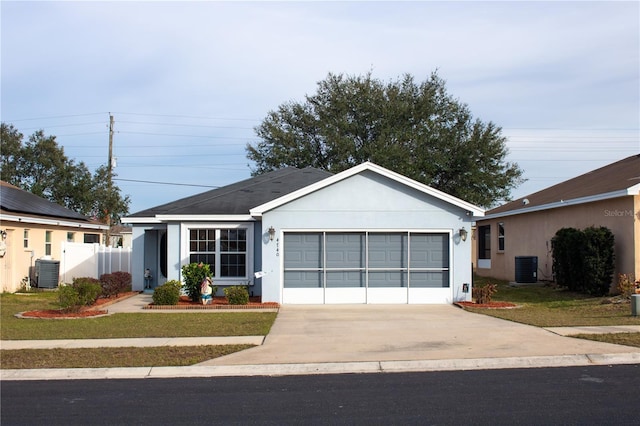 ranch-style home with a front yard, central AC, and a garage