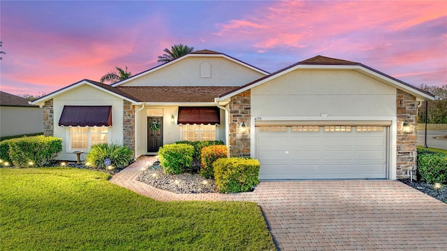 ranch-style house with a garage and a lawn