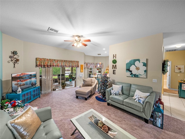 living room with a textured ceiling, ceiling fan, and carpet