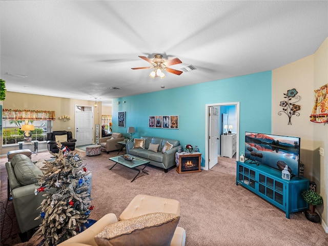 carpeted living room with a textured ceiling and ceiling fan