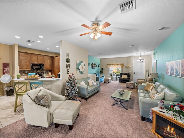 carpeted living room featuring a textured ceiling and ceiling fan