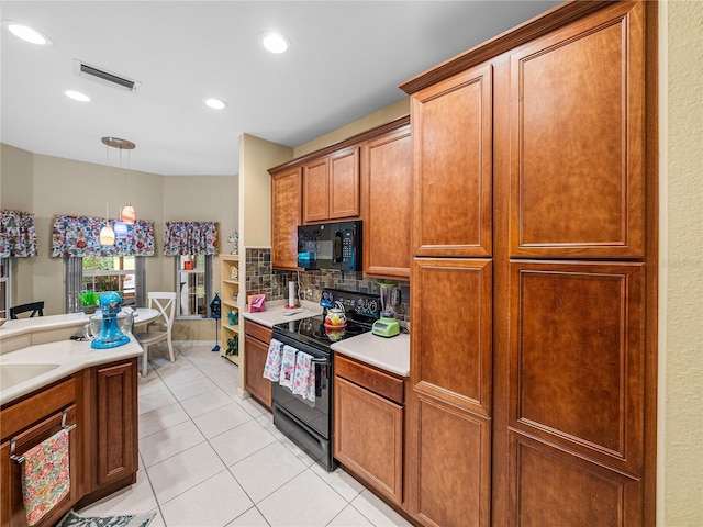 kitchen with sink, decorative light fixtures, light tile patterned floors, decorative backsplash, and black appliances