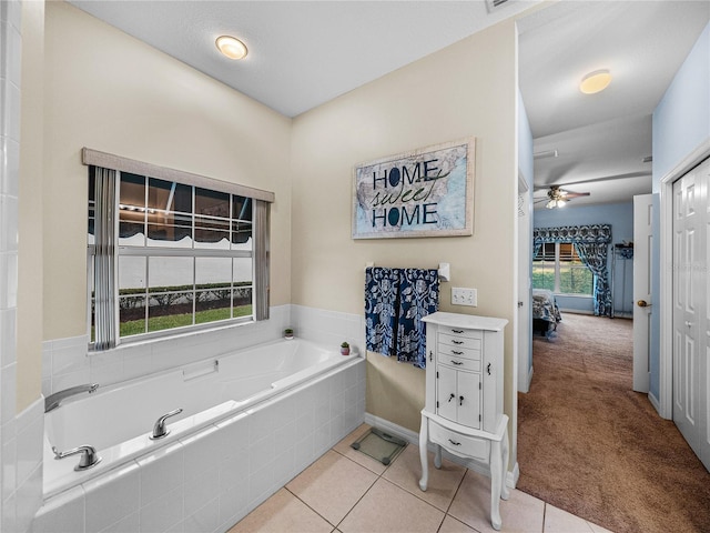 bathroom with tile patterned flooring, tiled bath, and ceiling fan