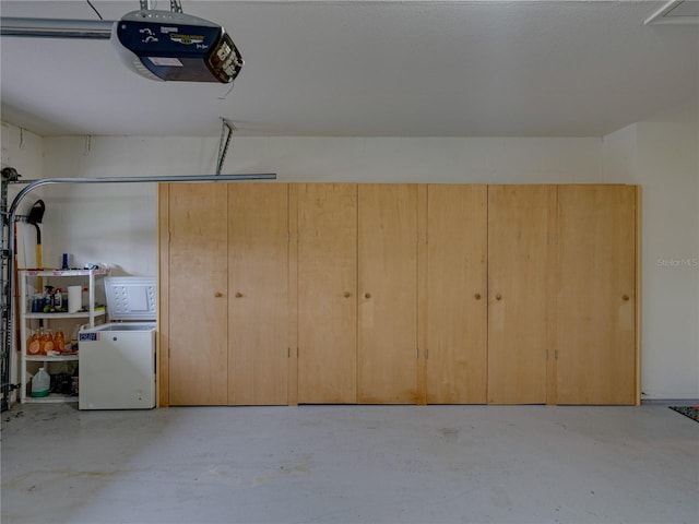 garage featuring fridge and a garage door opener