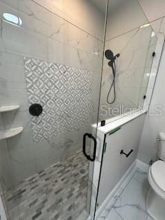 bathroom featuring an enclosed shower and toilet