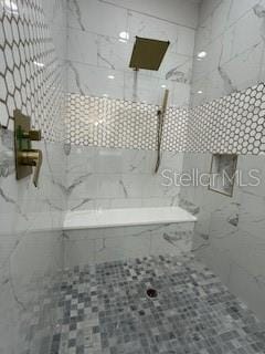 bathroom featuring tile patterned floors and tiled shower