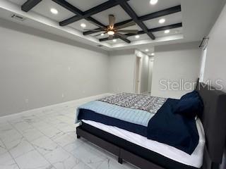 bedroom featuring coffered ceiling and beam ceiling