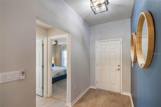 hallway featuring baseboards and light wood-style floors