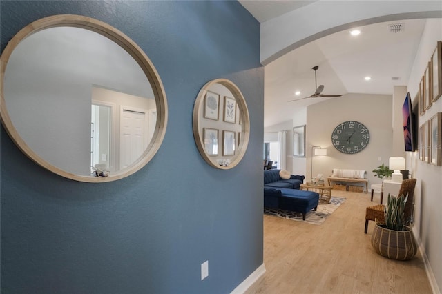 corridor featuring lofted ceiling, recessed lighting, visible vents, light wood-style floors, and baseboards