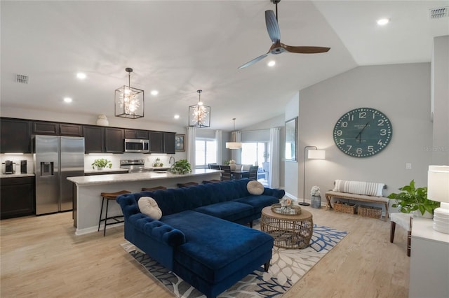 living area with lofted ceiling, recessed lighting, visible vents, and light wood-style floors