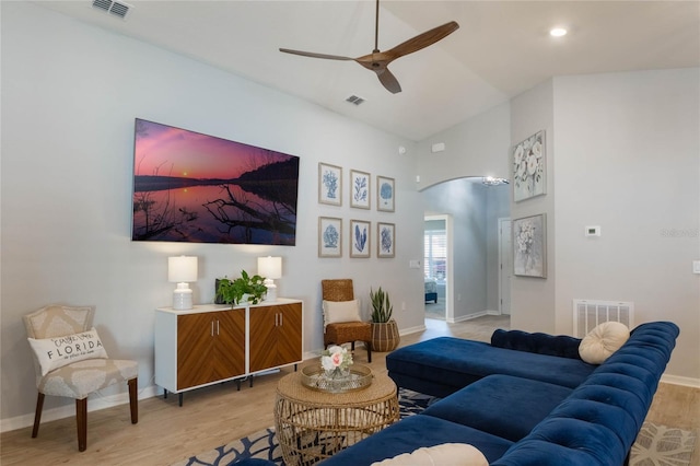 living room with ceiling fan, vaulted ceiling, and light hardwood / wood-style flooring