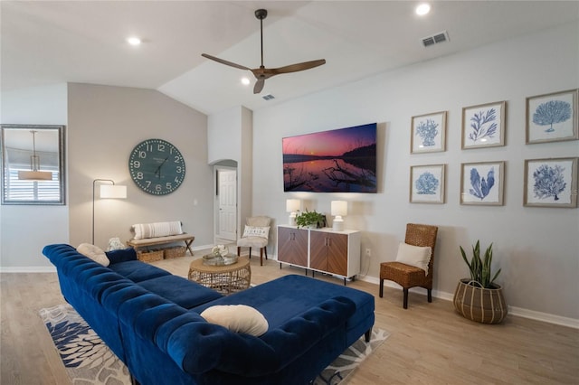 living room with vaulted ceiling, ceiling fan, and light wood-type flooring