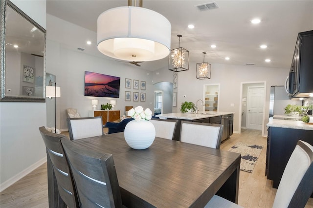 dining area with sink and light wood-type flooring