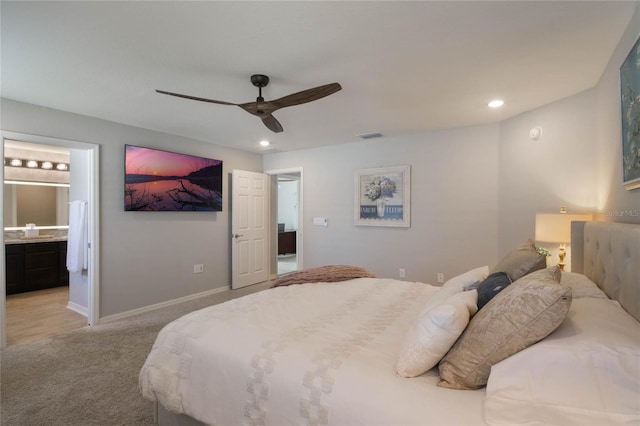 bedroom featuring ensuite bathroom, sink, light carpet, and ceiling fan