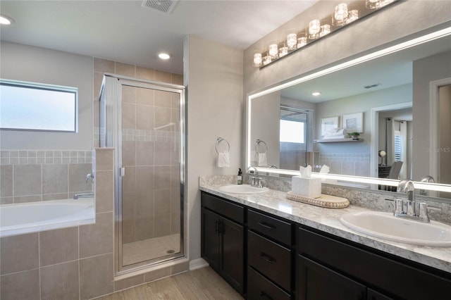 bathroom with hardwood / wood-style flooring, vanity, and shower with separate bathtub