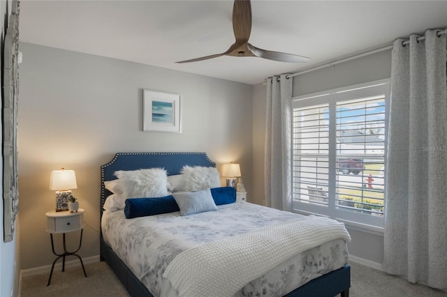 carpeted bedroom featuring multiple windows and ceiling fan