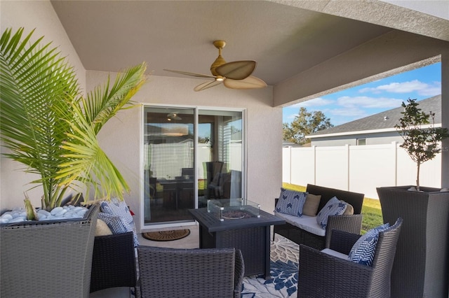 view of patio with ceiling fan and an outdoor living space with a fire pit