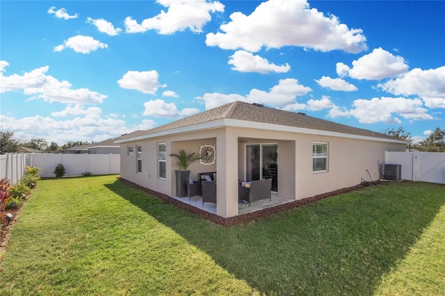 rear view of property with a patio, central AC, and a lawn