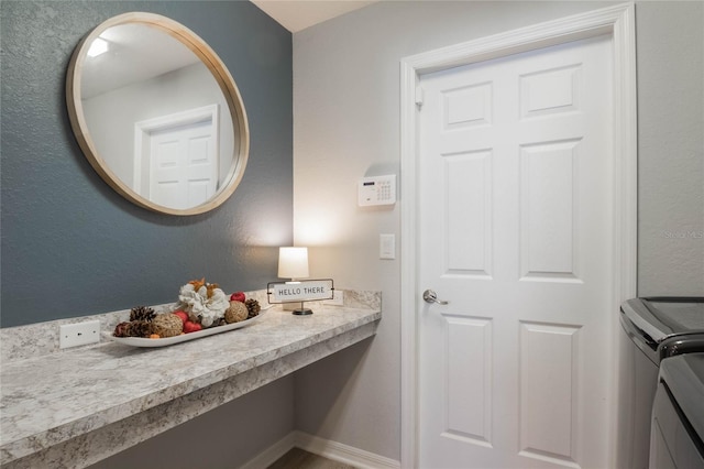 bathroom featuring baseboards and washing machine and clothes dryer