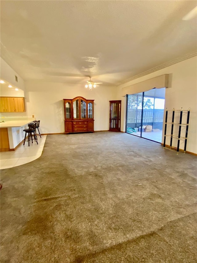 unfurnished living room with carpet flooring and ceiling fan