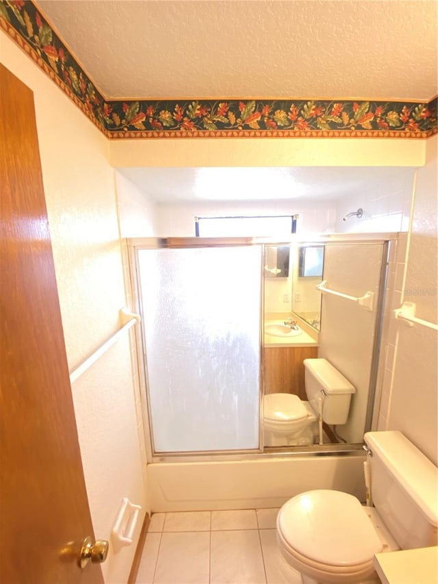 full bathroom with tile patterned floors, enclosed tub / shower combo, a textured ceiling, toilet, and vanity