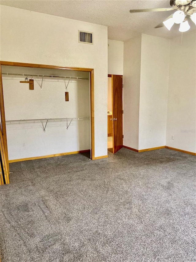 unfurnished bedroom with a textured ceiling, carpet flooring, and ceiling fan