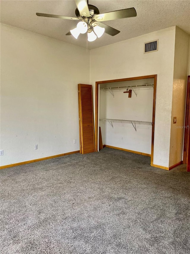 unfurnished bedroom featuring a closet, ceiling fan, carpet flooring, and a textured ceiling