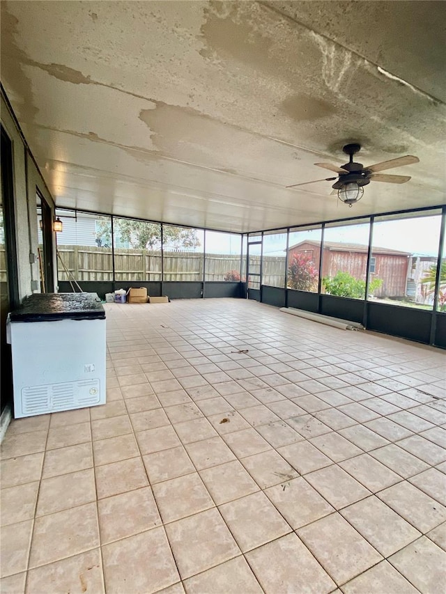 unfurnished sunroom featuring ceiling fan