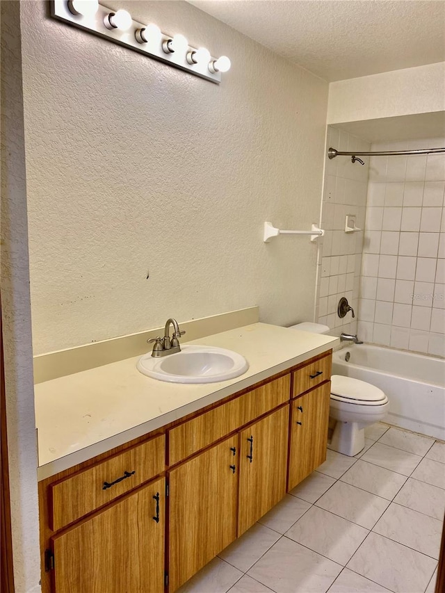 full bathroom featuring toilet, a textured ceiling, tile patterned floors, vanity, and tiled shower / bath