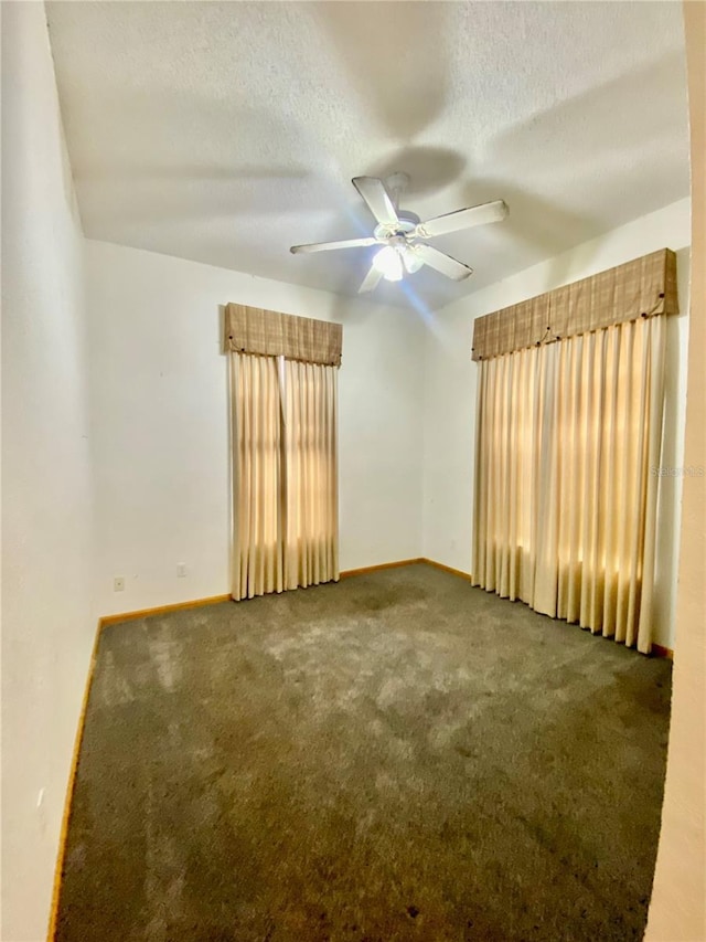 empty room featuring ceiling fan, a textured ceiling, and carpet