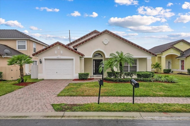 mediterranean / spanish home featuring a front lawn and a garage