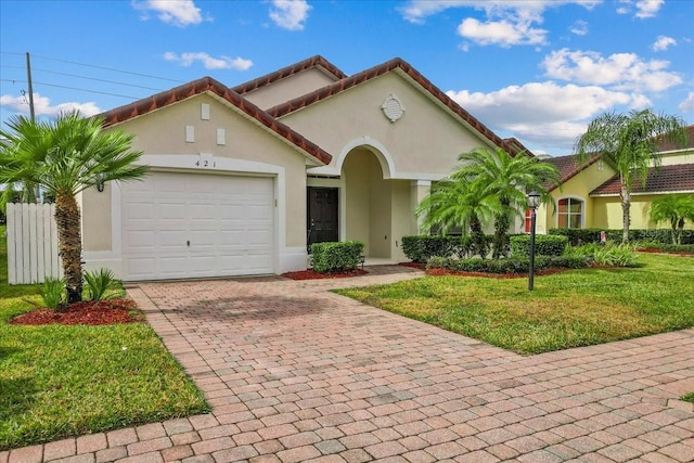 mediterranean / spanish-style home with a garage and a front yard