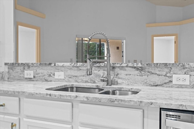 kitchen featuring white cabinets, dishwasher, sink, and light stone counters