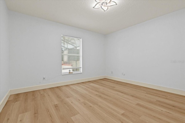 spare room featuring a textured ceiling and light wood-type flooring