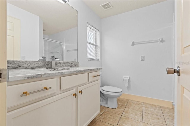 bathroom featuring an enclosed shower, vanity, tile patterned flooring, and toilet