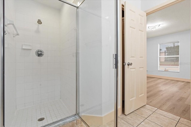 bathroom featuring a textured ceiling, tile patterned floors, and walk in shower