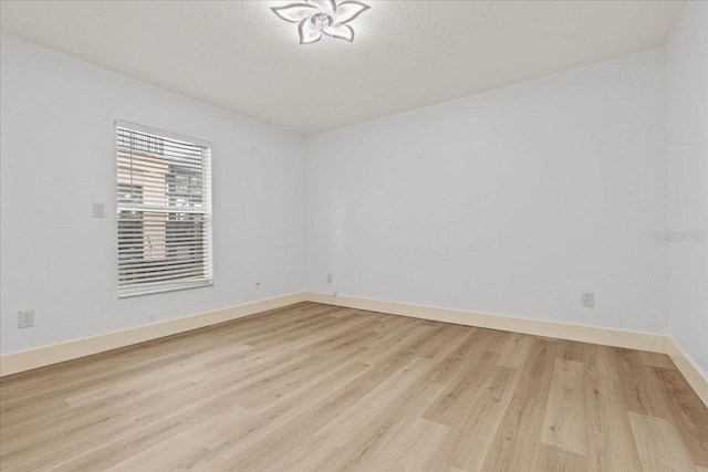 unfurnished room with light hardwood / wood-style floors and a textured ceiling