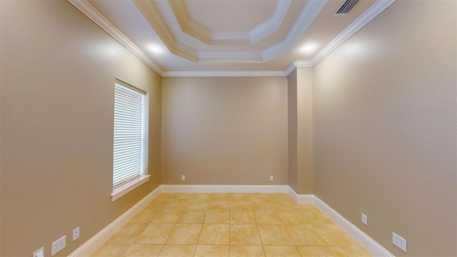 tiled spare room featuring a tray ceiling and ornamental molding